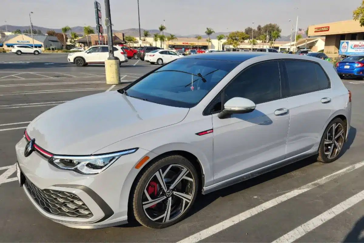 a white car in a parking lot with glossy finish