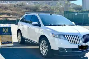 White SUV with paint protection film parked beside detailing shop sign