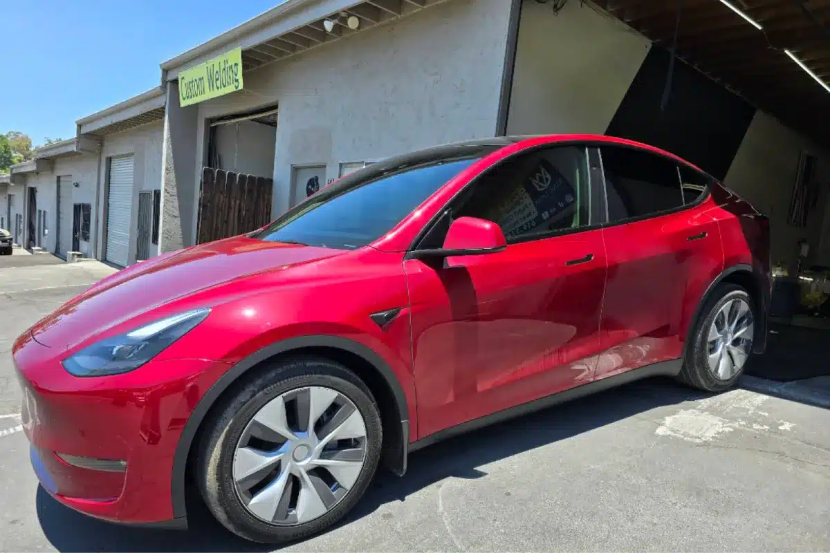 Red Tesla Model Y showing glossy paint protection film finish.