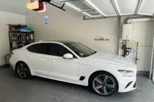 White Genesis sedan protected with ceramic coating in a garage.