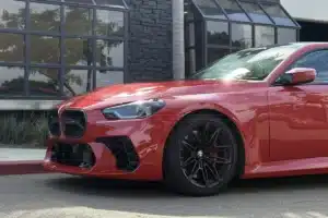 Close-up of a red BMW with paint protection film on the front end.