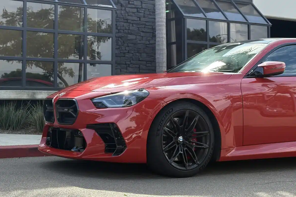 Close-up of a red BMW with paint protection film on the front end.