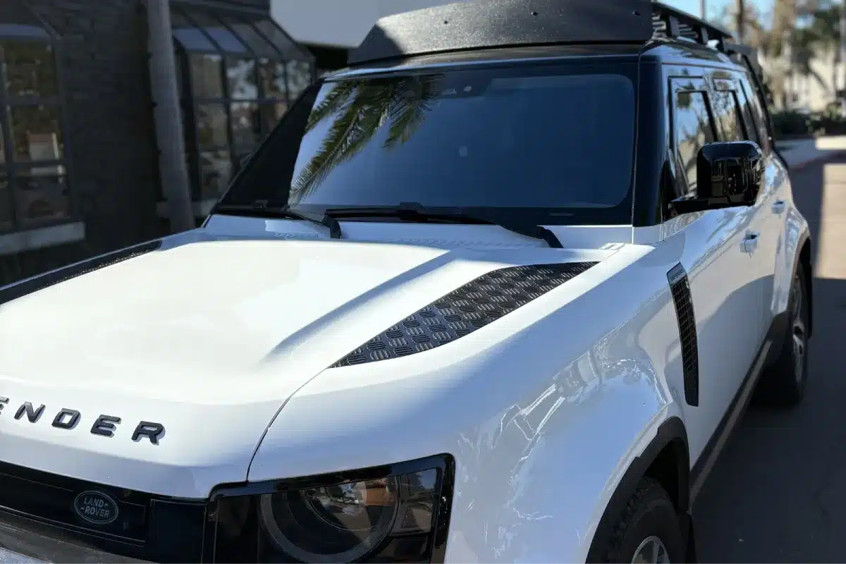 White Land Rover Defender with dark window tint.